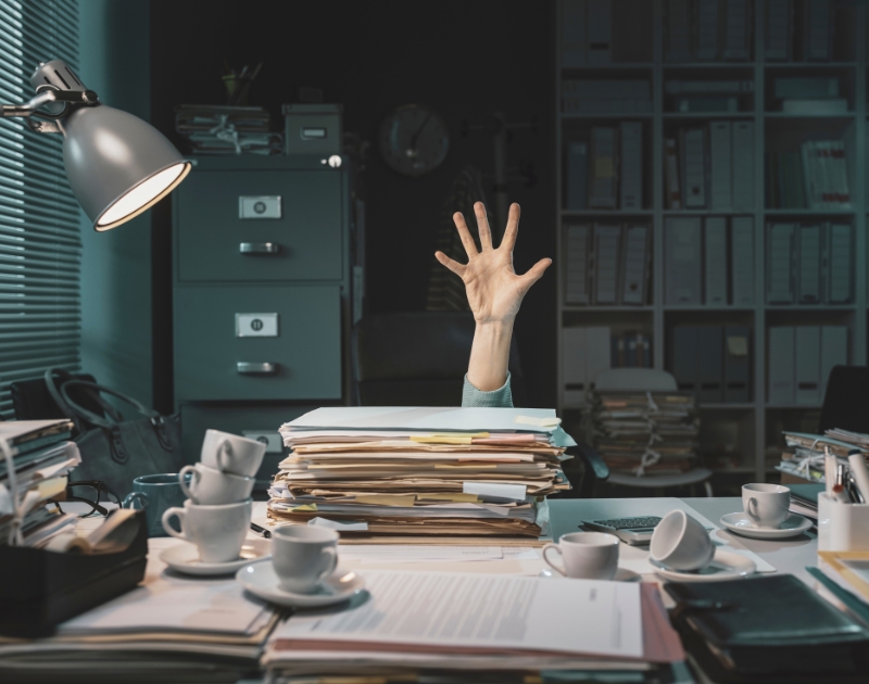 Office worker overwhelmed with accounting books