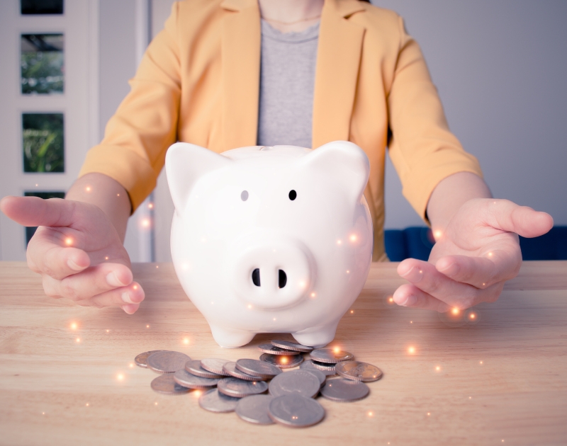 Businesswoman take a position to protect on the payroll symbolized by the piggybank